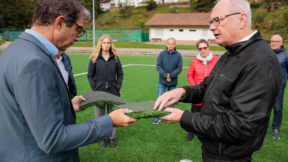 Staatssekretär Dr. Andre Baumann in Heiligkreuzsteinach im Gespräch über Mikroplastik in Kunststoffrasenplätzen.