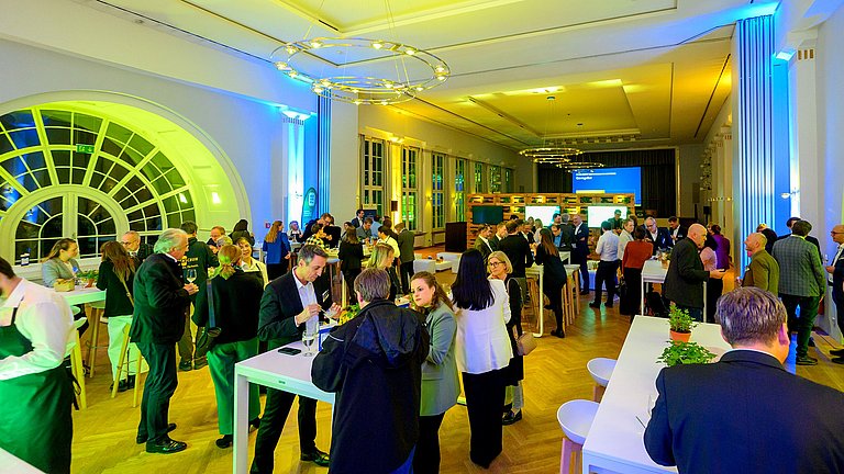 Viele Unternehmensvertreterinnen und -vertreter tauschen sich im Rahmen einer Veranstaltung zum Klimabündnis Baden-Württemberg intensiv aus.