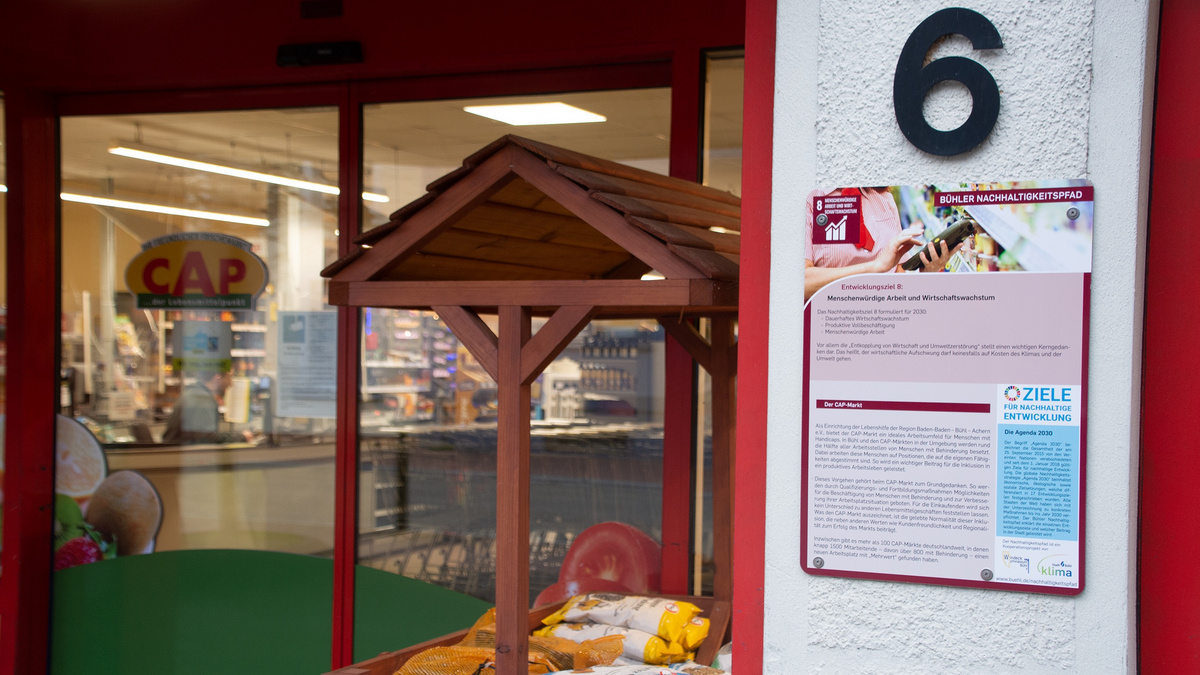 Das Farbfoto zeigt eine Informationstafel, die vor einem Supermarkt hängt. Die Überschriften „Bühler Nachhaltigkeitspfad“ und „Ziele für nachhaltige Entwicklung“ sind groß aufgedruckt.