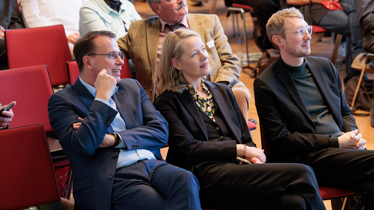 Das Farbfoto zeigt aufmerksame Zuhörerinnen und Zuhörer im Publikum auf roten Stühlen sitzend. Darunter sind Umweltministerin Thekla Walker MdL und der Kultusstaatssekretär Volker Schebesta MdL.